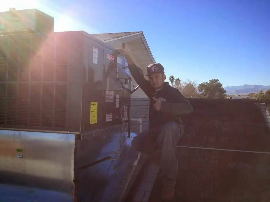 HVAC technician performing AC Tune-Up on a rooftop unit in Silver Firs